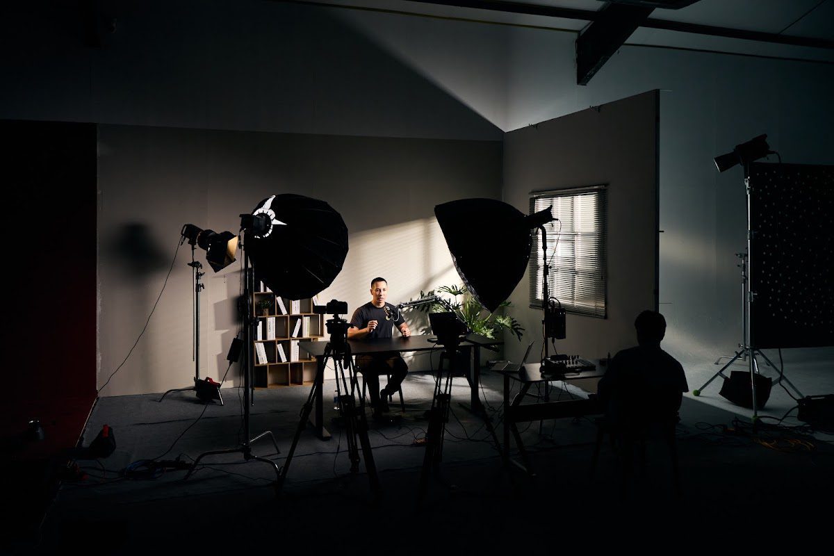 Two hosts recording a podcast on a lit interview set at CINEFY studio in Da Nang