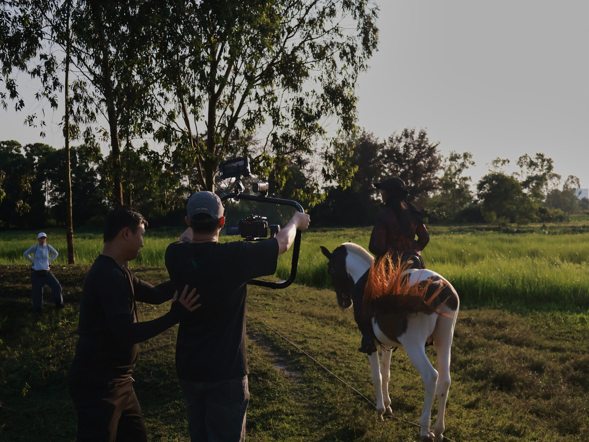 CINEFY crew setting up a camera in a field in late afternoon light near Da Nang