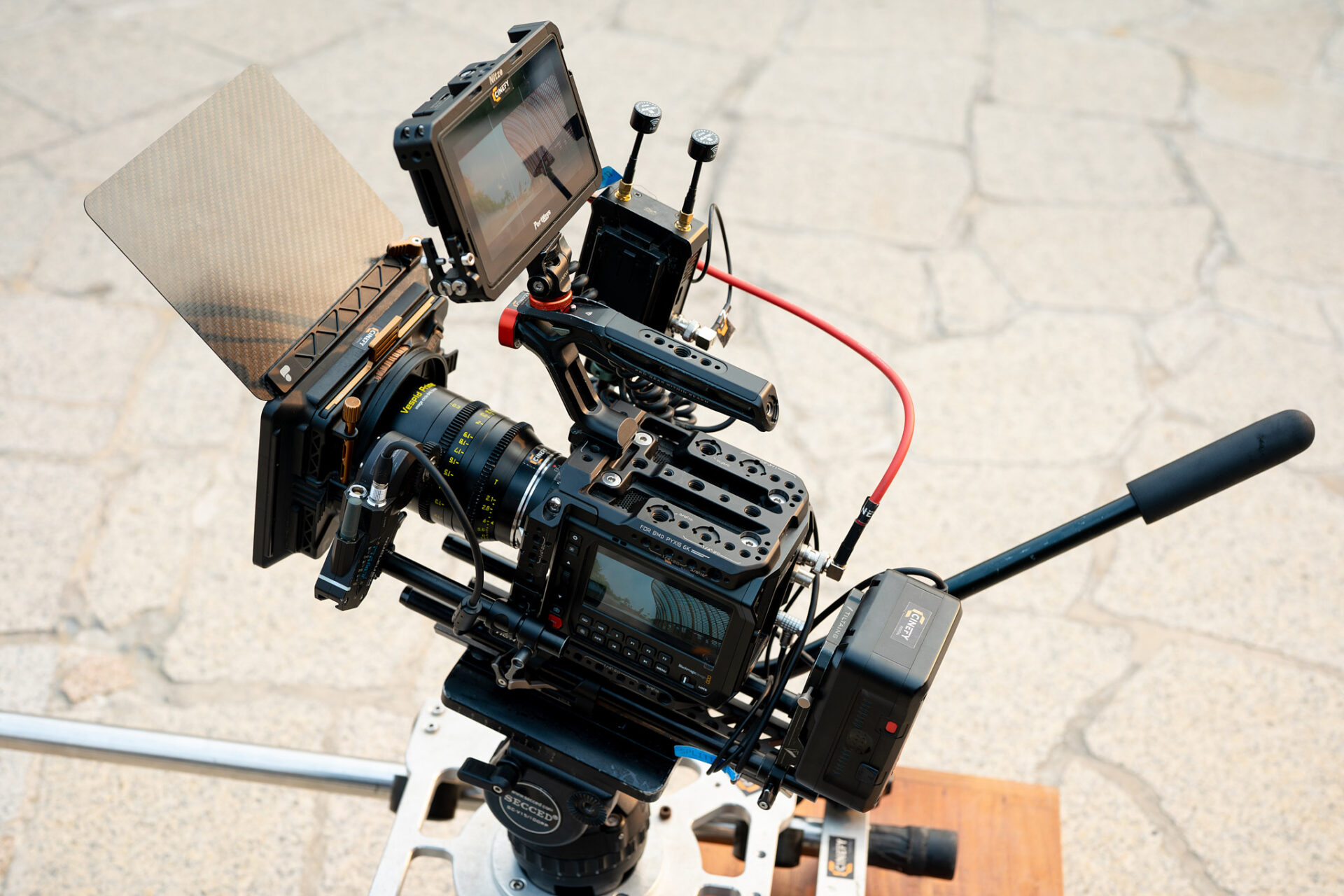 Cinema camera with matte box and shotgun mic sitting on sun blasted paving during an outdoor shoot in Da Nang
