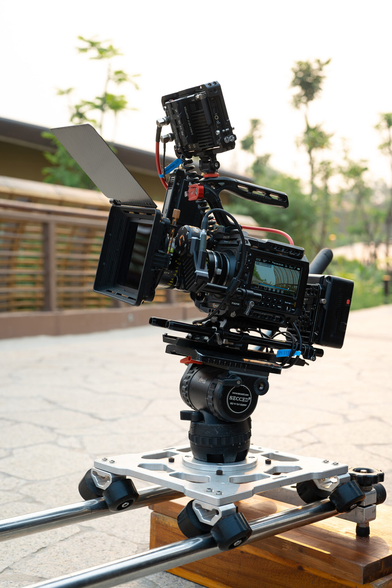 Black camera body with matte box standing in daylight during an exterior shoot in Da Nang