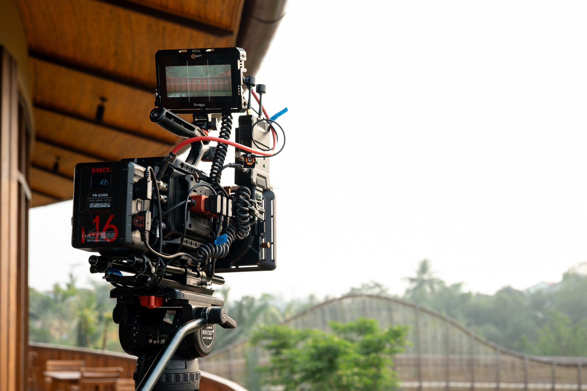 Cinema camera resting under a roof in the shade between exterior scenes in Da Nang