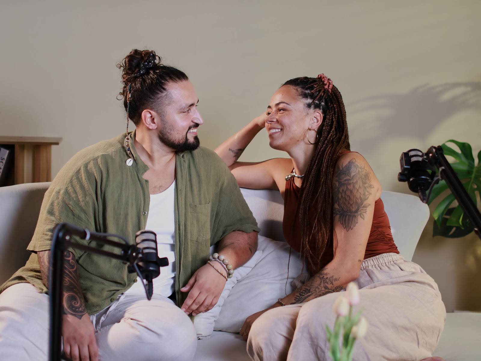 Two guests talking naturally on the sofa set during a guided recording at a podcast studio in Da Nang.