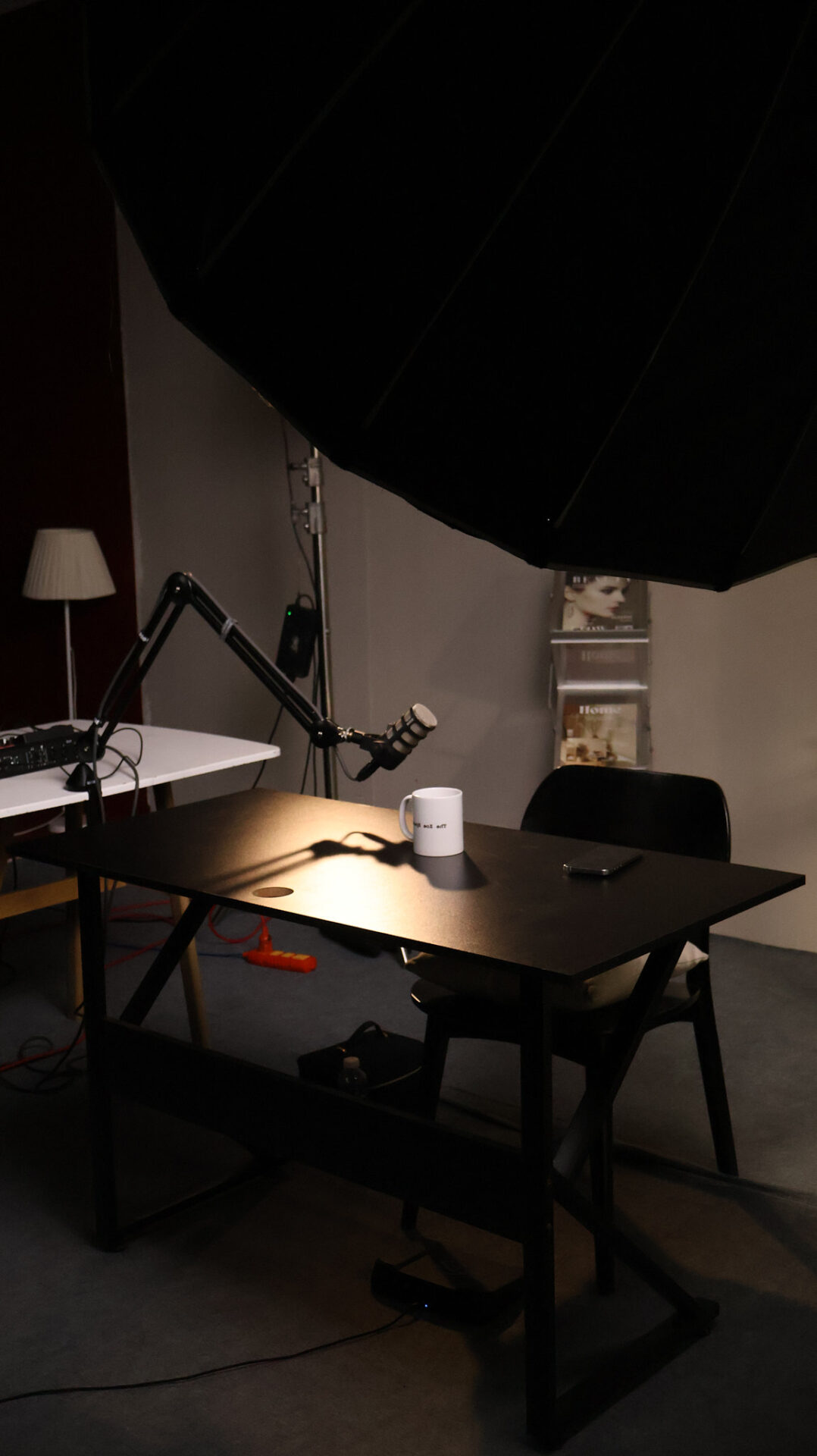 Podcast recording table with broadcast microphone arms set up and ready at a podcast studio in Da Nang.
