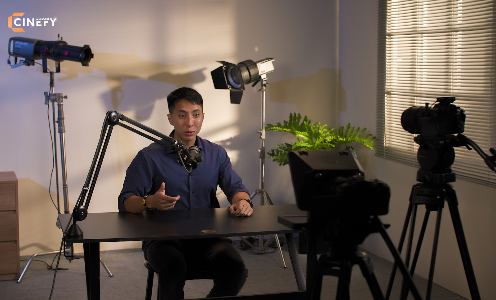 Creator recording talking-head video content on a cinema camera at a podcast studio in Da Nang.