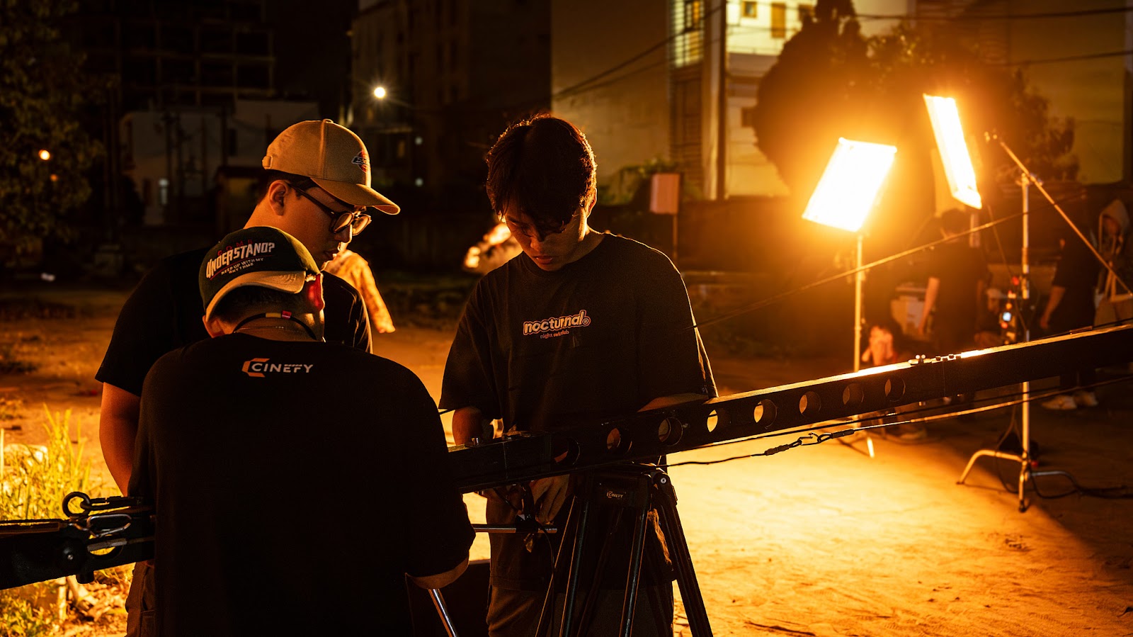CINEFY crew members talking beside a slider and lights during a video production company shoot in Da Nang.