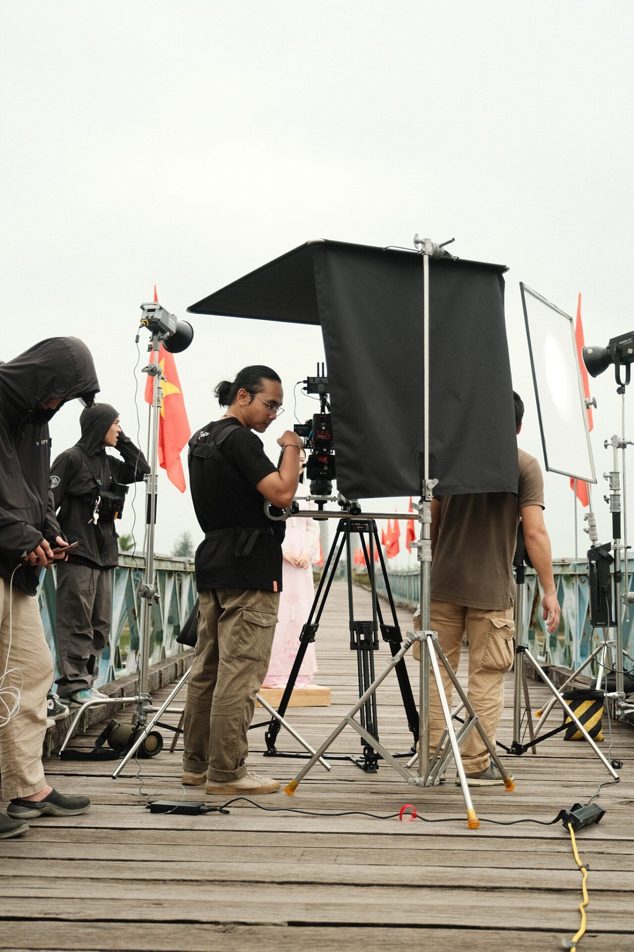 CINEFY lighting crew building fixtures and a diffusion frame against a white backdrop in the Da Nang studio