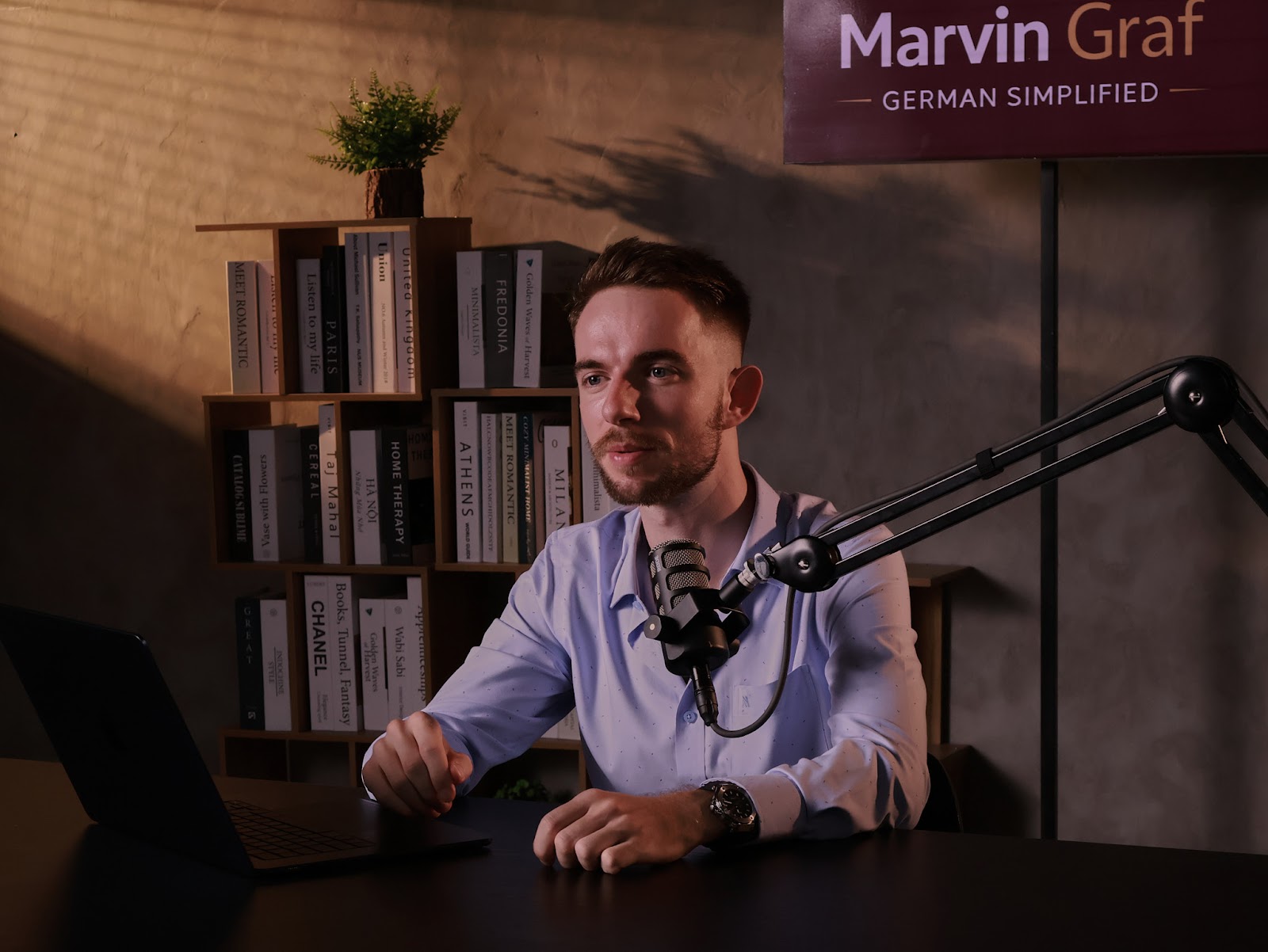 A guest speaking into a boom-mounted microphone during a podcast session at CINEFY studio in Da Nang