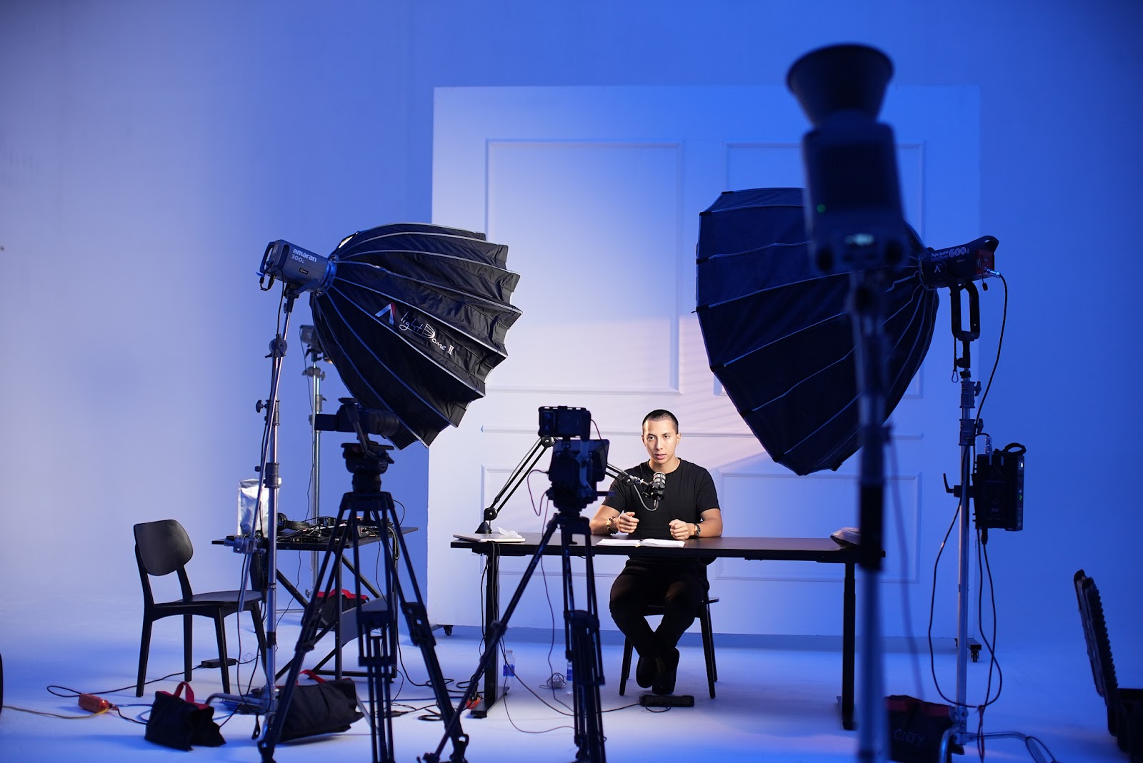 CINEFY crew building the set and lighting for a podcast shoot at the Da Nang studio