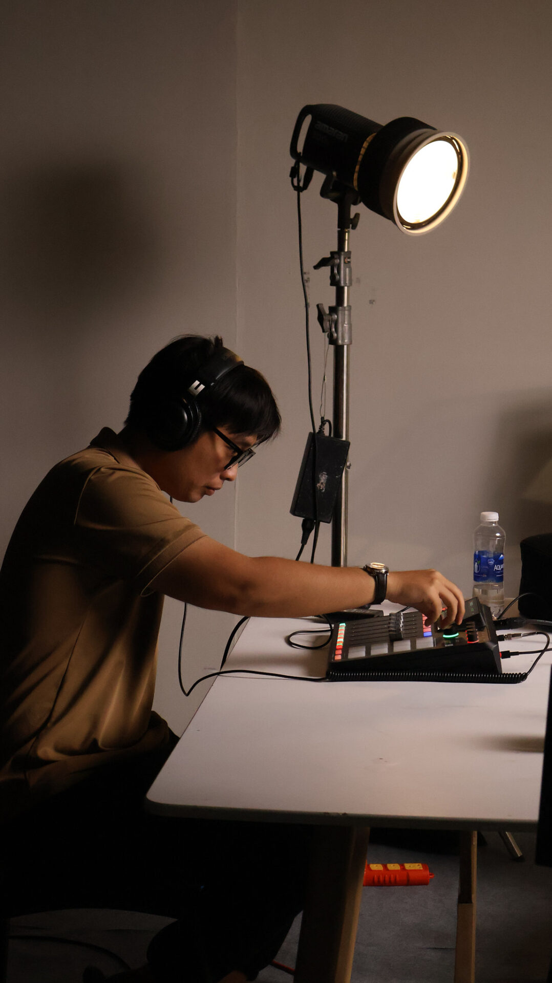 A sound technician on headphones watching levels on a mixer during a CINEFY shoot in Da Nang